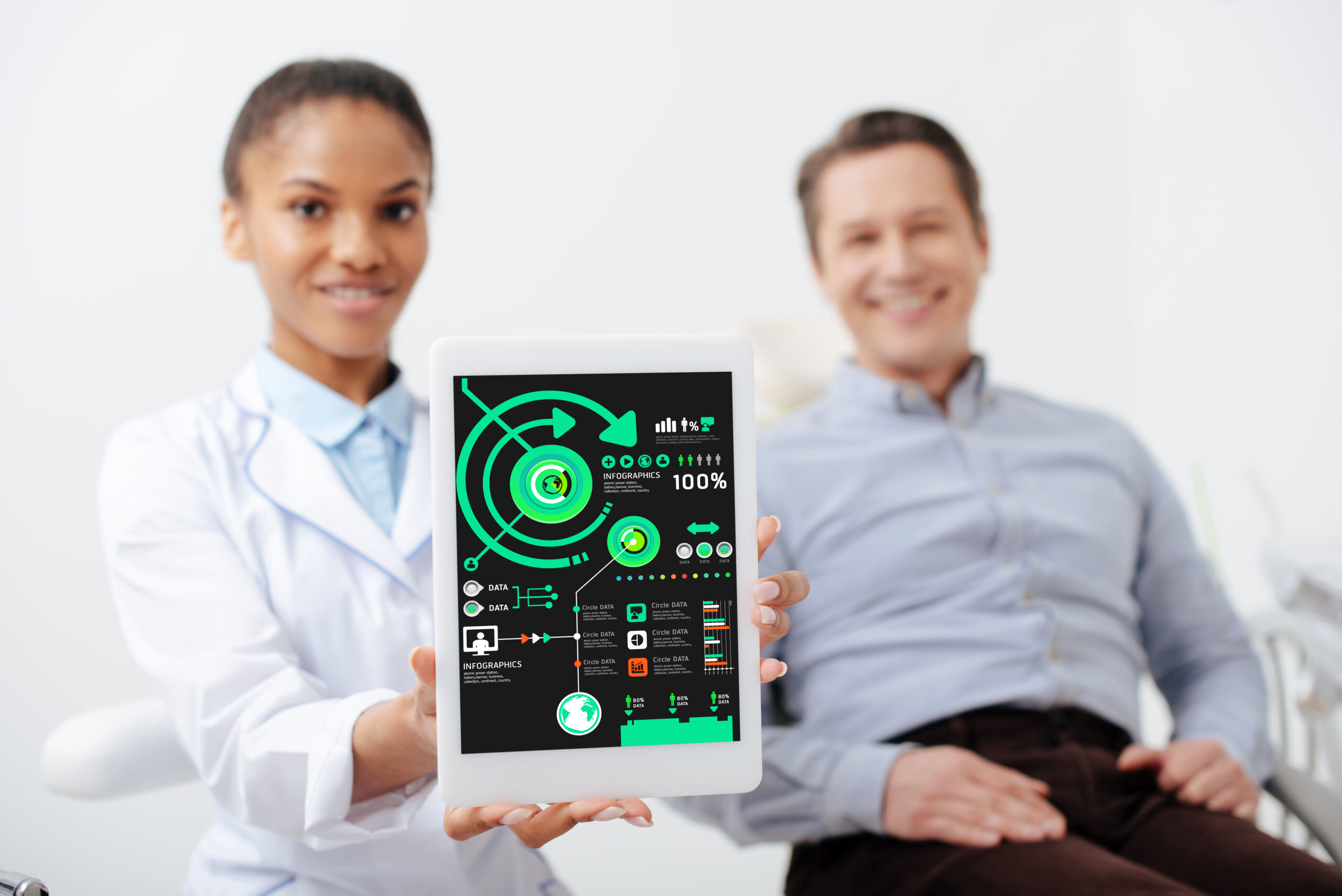 selective focus of cheerful african american dentist holding digital tablet with charts and graphs on screen near happy patient